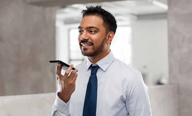 Businessman in shirt and tie using voice command recorder on smartphone
